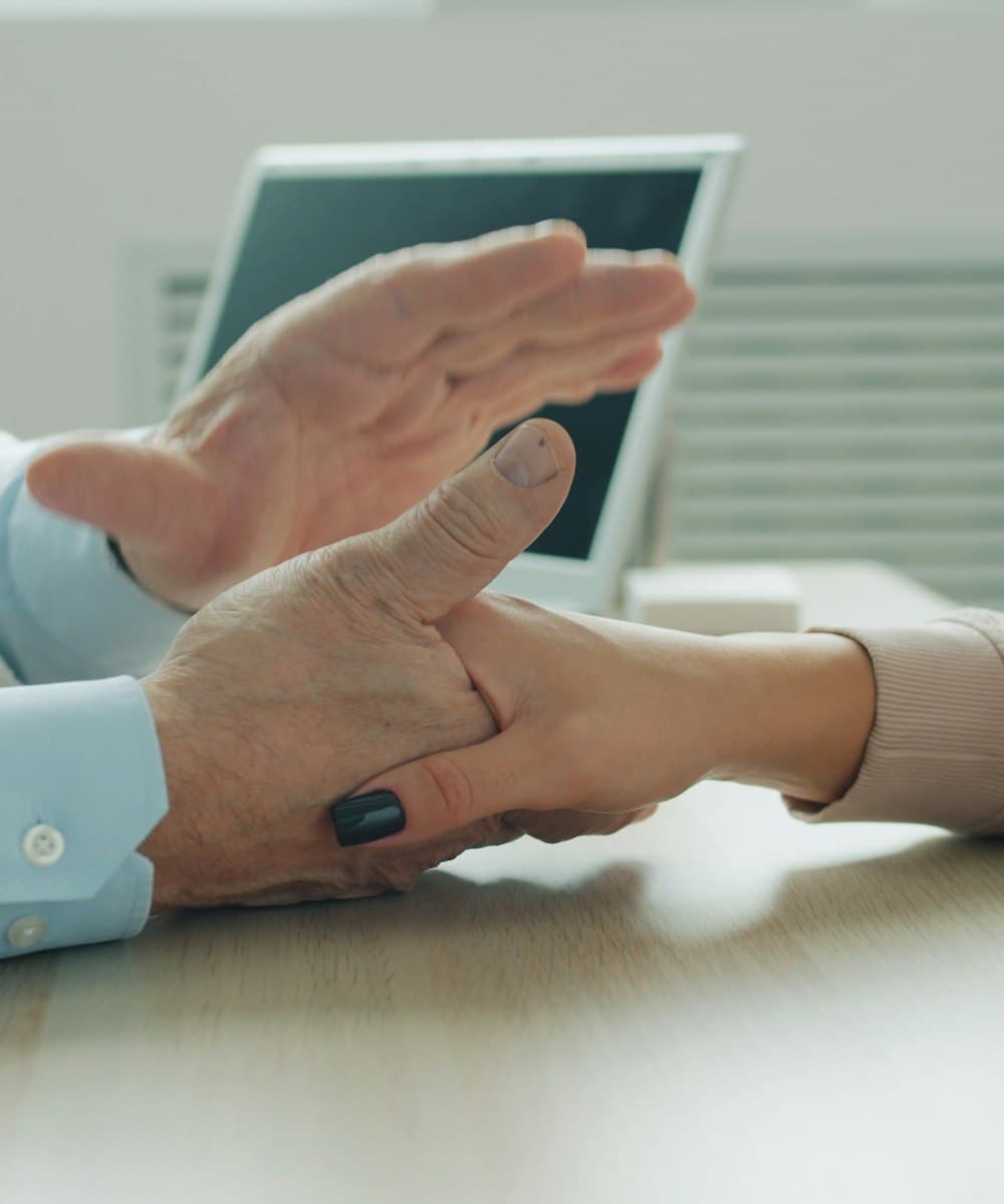 Profesional de la salud tomando la mano de una paciente durante la consulta